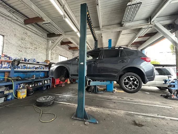 A Subaru up on the lift with a wheel off